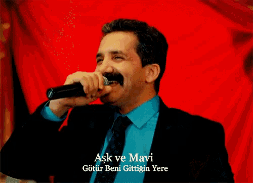 a man in a suit and tie is dancing with a woman in a black dress with the words ask ve mavi written on the bottom