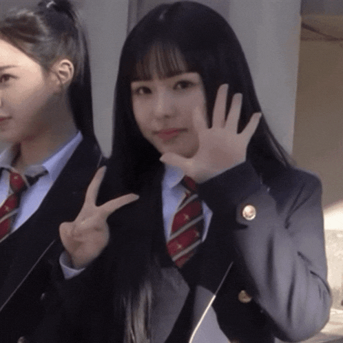 a girl in a suit and tie is giving a peace sign