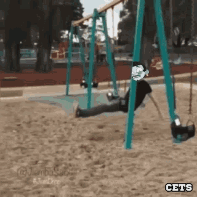 a person is sitting on a swing in a park with a cartoon character on it .