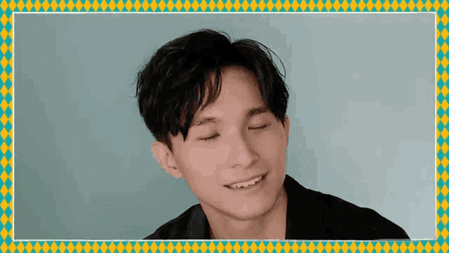 a young man with his eyes closed and a yellow and blue frame around him .