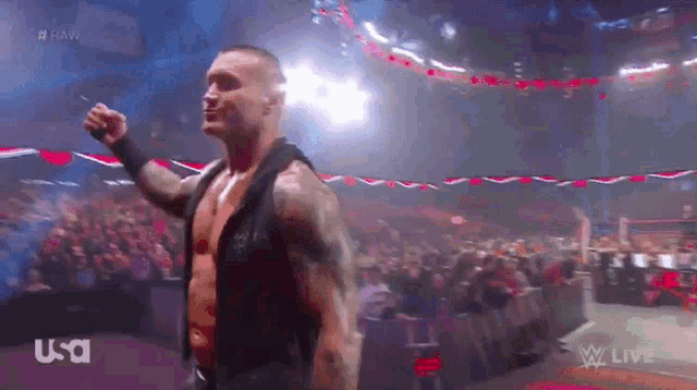 a man is standing in front of a crowd with his fist in the air