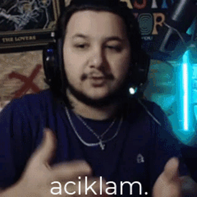 a man wearing headphones and a necklace with the word açiklam on the bottom