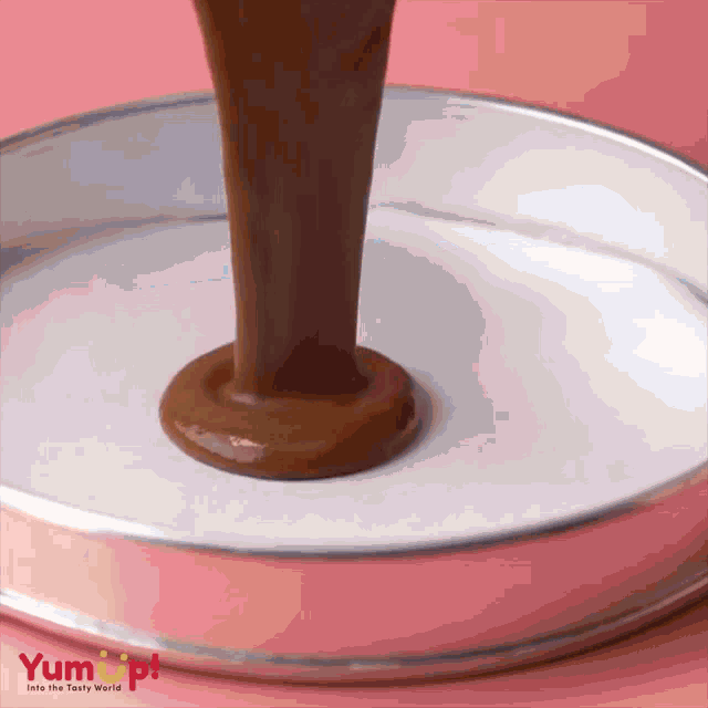 chocolate is being poured into a pan that says yum up on the bottom