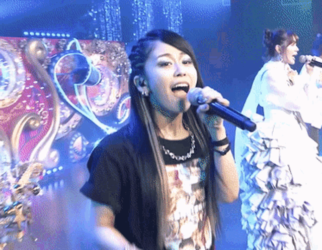 a woman singing into a microphone while wearing a t-shirt that says ' i love you ' on it