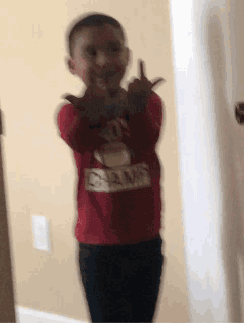 a boy wearing a red shirt that says champs on it