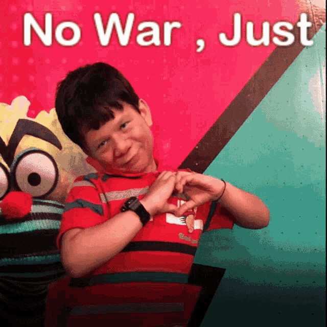 a boy making a heart with his hands in front of a sign that says " no war just "