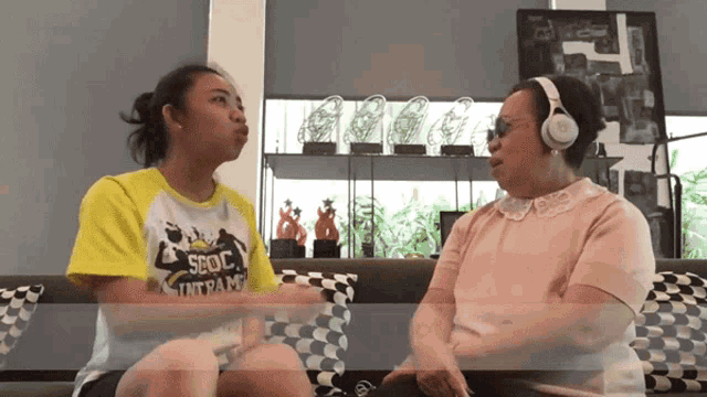 two women sitting on a couch with one wearing a shirt that says sdoc