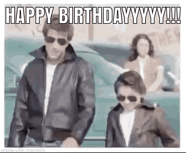 a man in a leather jacket is standing next to a boy in sunglasses .
