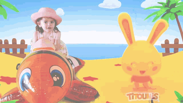 a little girl sits on an inflatable turtle next to an inflatable bunny