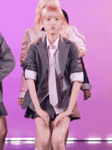 a girl in a suit and tie is dancing on stage