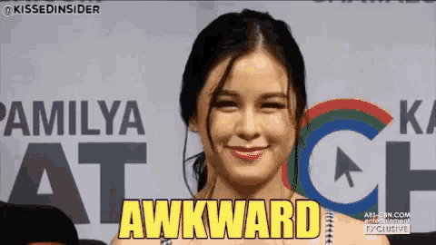 a woman is smiling in front of a sign that says " awkward "