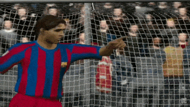 a man in a red and blue striped shirt is pointing at a net