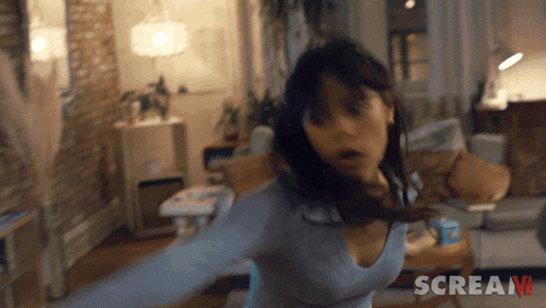 a woman in a living room with scream written on the bottom right