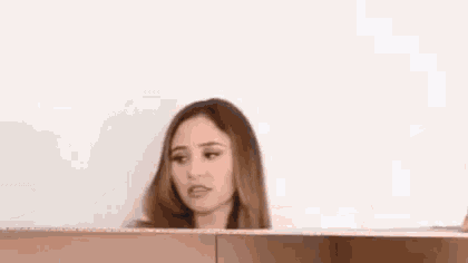 a woman is standing in a cardboard box and looking out of it .