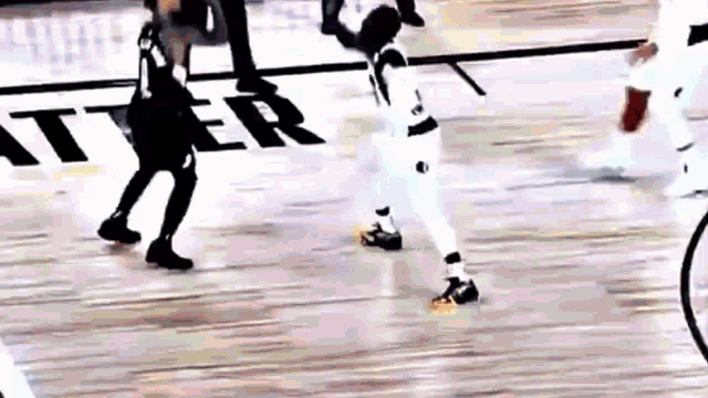 a basketball game is being played on a court with a referee .