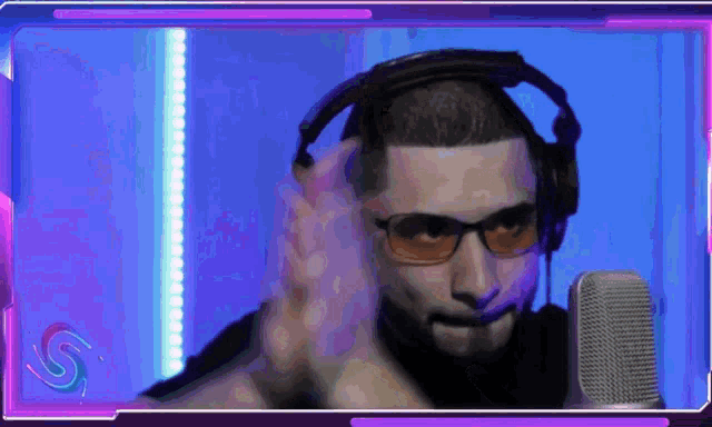 a man wearing headphones and glasses looks at the camera