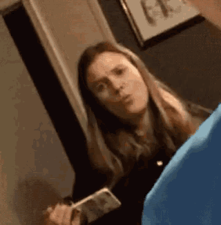a woman in a blue shirt is talking to a man