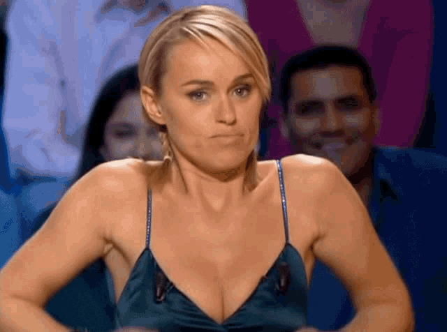 a woman in a very revealing dress is sitting in front of a crowd
