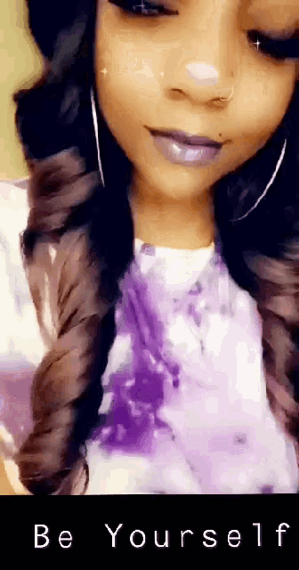 a woman wearing a purple shirt with the words be yourself written on the bottom