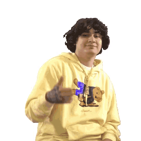 a young man in a yellow sweatshirt is giving a thumbs down sign .