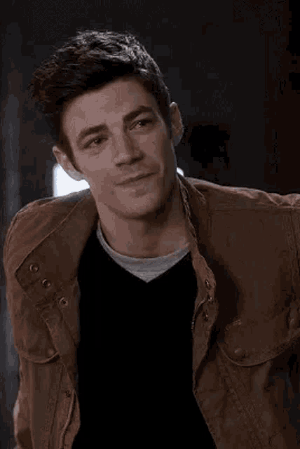 a close up of a man wearing a brown jacket and a black sweater .