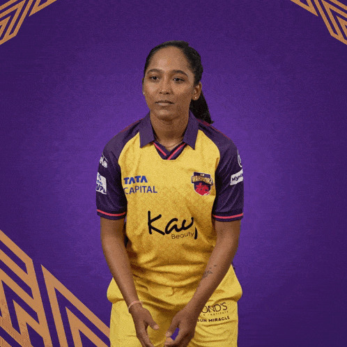 a woman is wearing a yellow and purple jersey that says tata capital