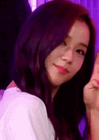 a close up of a woman 's face with purple hair and a white shirt .