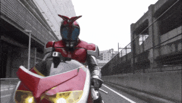 a person in a red and black costume is riding a red and white motorcycle