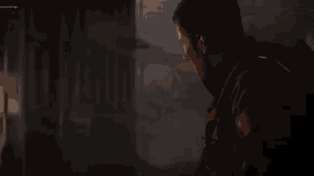 a person is standing in front of a burning building in the dark .