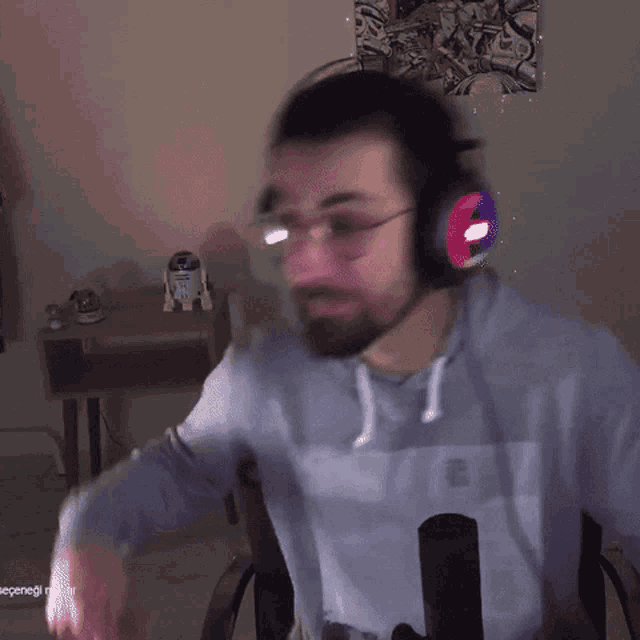 a man with a beard wearing headphones and a sweatshirt with a picture of a woman on it