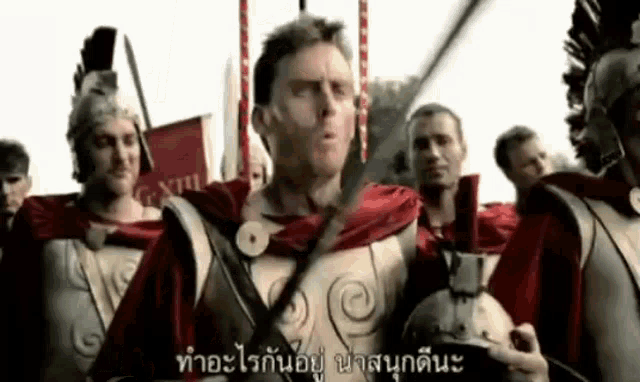 a group of roman soldiers are standing in a line holding swords .