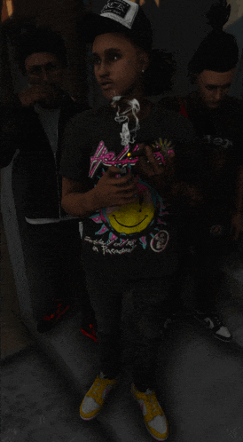 a man wearing a black shirt with a smiley face on it is smoking a cigarette