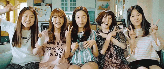a group of young women are sitting next to each other on a couch .