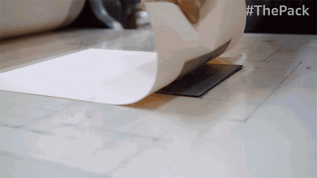 a piece of paper is being rolled up with the hashtag #thepack on the bottom