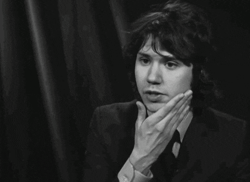 a black and white photo of a young man in a suit
