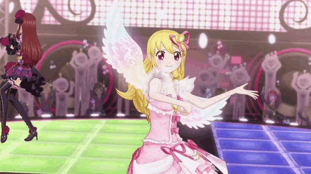 a girl in a pink dress with angel wings is dancing
