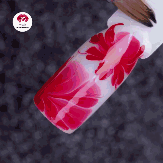 a close up of a nail with a red flower design and the words nails inspiration
