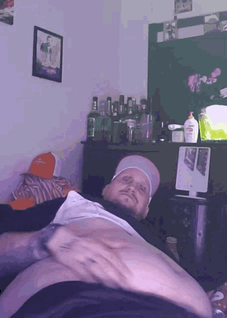 a man is laying on a bed with a picture of a man on the wall