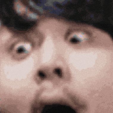 a close up of a man 's face with a surprised look on his face