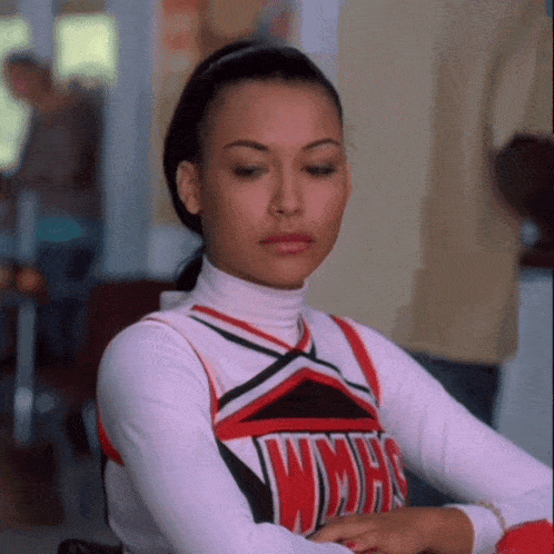 a woman wearing a wmhs cheerleader uniform sits at a table
