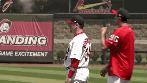 two baseball players are standing in front of a springfield sign