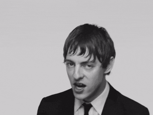 a man in a suit and tie making a face