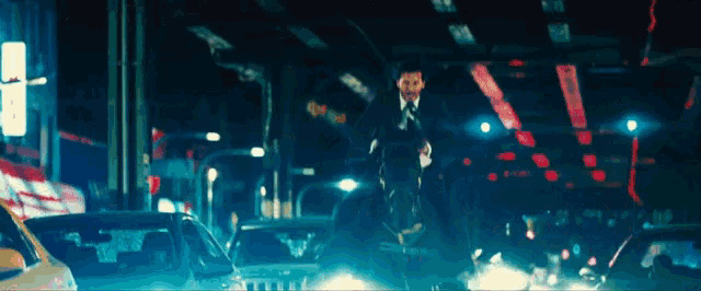 a man in a suit and tie is walking through a busy city street at night