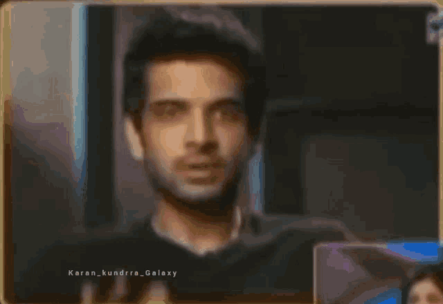 a man is waving his hand in front of a mirror .