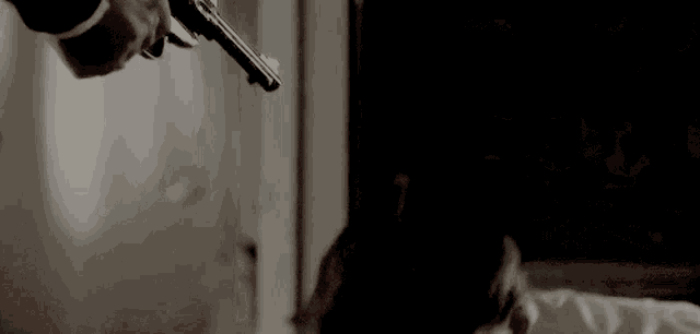 a man is holding a gun to his head while talking on a cell phone .