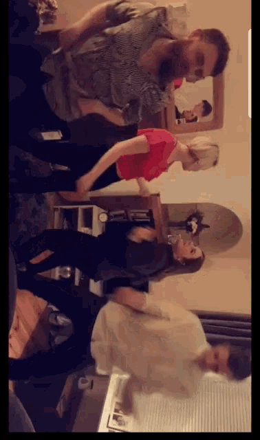 a group of people dancing in a living room