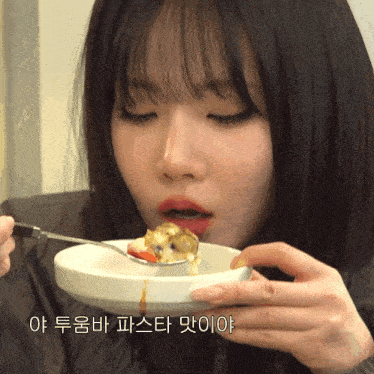 a woman is eating a bowl of food with a spoon in her mouth with korean writing on the bottom right
