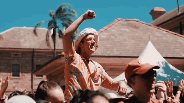 a man with his fist in the air is surrounded by a crowd of people