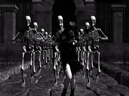 a woman in a black dress is surrounded by skeletons in a black and white photo
