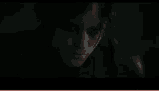 a close up of a person 's face in a dark room with a red border .